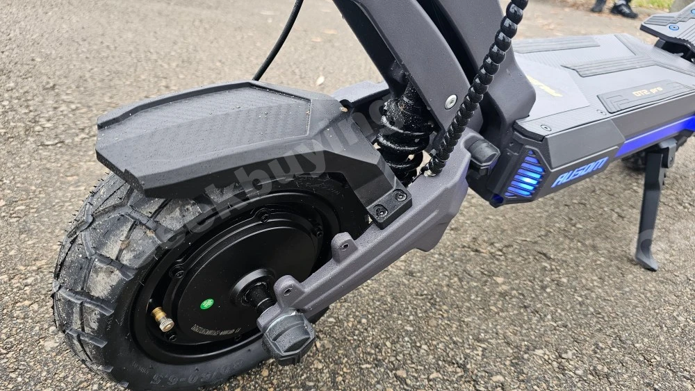 Close-up detail of the heavy-duty swing-arm suspension and 10-inch knobby off-road tires on the Ausom DT2 Pro.