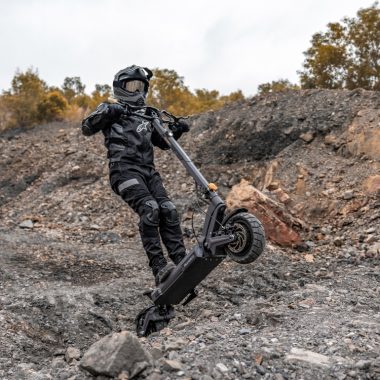 Scooter eléctrico Ausom DT2 Pro circulando por una calle de la ciudad, mostrando su amplia cubierta, suspensión dual, y diseño estable de desplazamientos urbanos